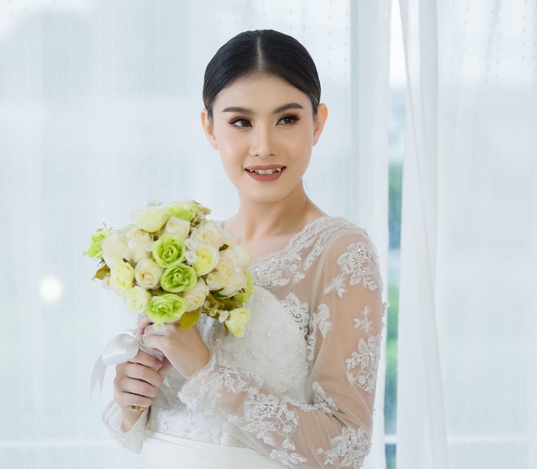 Beautiful bride with wedding flowers bouquet